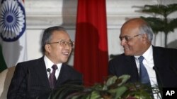 2012年1月17日，中国国务委员戴秉国(左)和印度国家安全顾问梅农在新德里签署一项协议后笑脸相对。