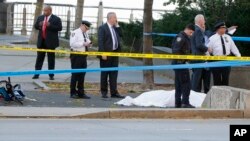 警方在出事現場調查。一名死者遺體被蒙上白布