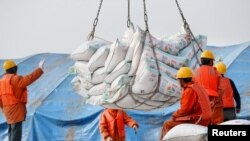 2018年3月22日，中國江蘇省南通港口工人裝卸進口的大豆產品。