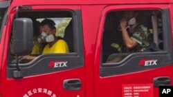 戴上口罩的消防員在天津爆炸現場附近待命