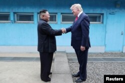 แฟ้มภาพ - อดีตปธน.โดนัลด์ ทรัมป์ จับมือกับ คิม จอง อึน ผู้นำเกาหลีเหนือ ที่เขตปลอดทหารระหว่างสองเกาหลี เมื่อ 30 มิ.ย. 2562