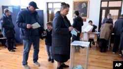 FILE - People vote at a polling station during the first round of presidential elections in Sukhumi, Georgia's breakaway region of Abkhazia, Feb. 15, 2025.