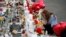 Gloria Garces kneels in front of crosses at a makeshift memorial near the scene of a mass shooting at a shopping complex, Aug. 6, 2019, in El Paso, Texas.