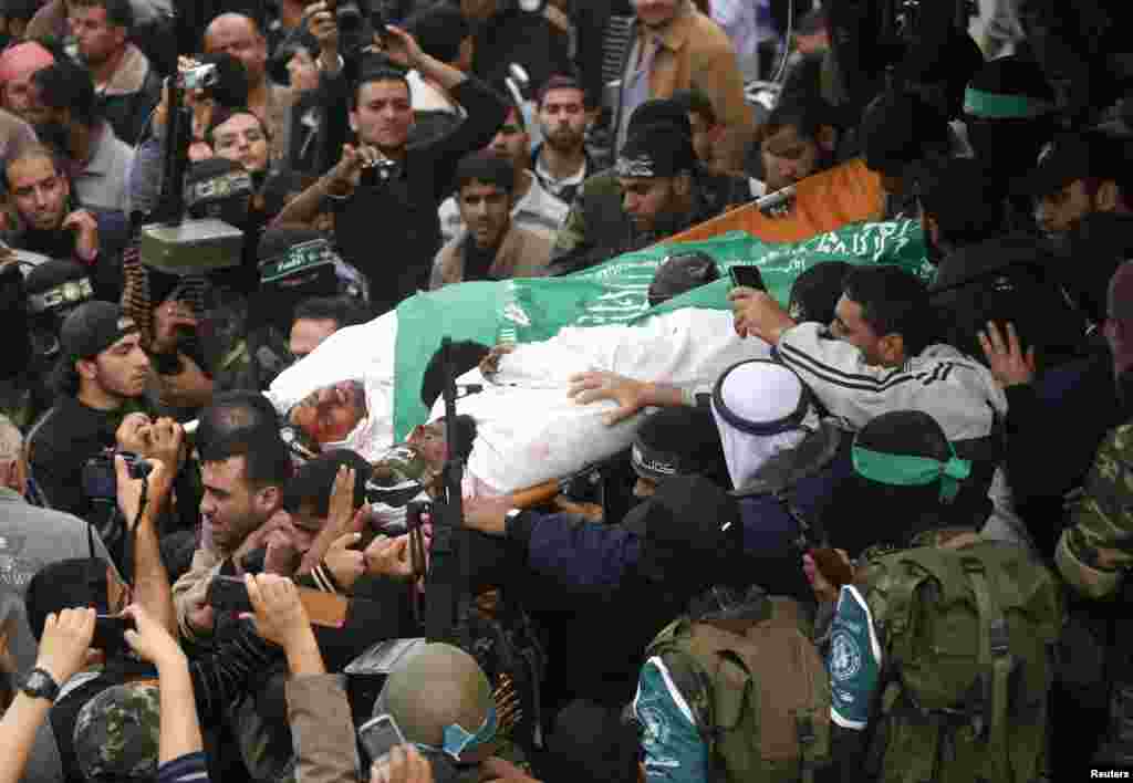 2012年11月22日，哈马斯激进分子在加沙地带中部举行的葬礼中抬着战友的尸体。医疗救护人员说，他们11月22日死于以色列空袭。