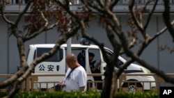 一名市民走過北京長安街一座橋下正在執勤的警車。（2024年6月4日）