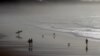 FILE - People walk on the beach of Biarritz, southwestern France, along the Atlantic Ocean, Dec. 18, 2015. New research shows the oceans are storing much more heat than previously thought.