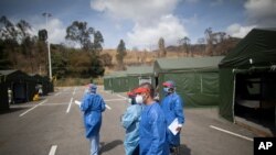Trabajadores de la salud caminan en un hospital de campaña instalado en el estacionamiento del auditorio Poliedro de Caracas, en Venezuela. Marzo 21, 2021. Foto: AP.