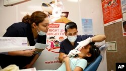 ແຟ້ມ-ນັກຮຽນແພດປົວແຂ້ວຂອງລັດຢູທາ ເປັນອາສາສະໝັກຈັດການກວດກາແຂ້ວໃຫ້ຟຣີສໍາລັບເດັກນ້ອຍ ເຊິ່ງເປັນສ່ວນນຶ່ງໃນເດືອນແຫ່ງສຸຂະພາບແຂ້ວຂອງຄອລເກດ ຢູ່ຂົງເຂດຟີສຕາ ມາດທ໌ ໃນນະຄອນຮຸສຕັນ, ວັນທີ 13 ມິຖຸນາ 2015. 