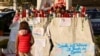 A child stands in front of candles, cards and other tributes to Pope Francis, outside Gemelli Hospital where the pope is being treated, in Rome, Italy, March 6, 2025.