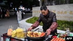 3月4日，一名街頭小吃攤販在中國西南部重慶市中心的街道上工作。