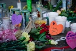 Candles burn as part of a memorial at the scene of Sunday morning’s mass shooting in Dayton, Ohio, Aug. 5, 2019.