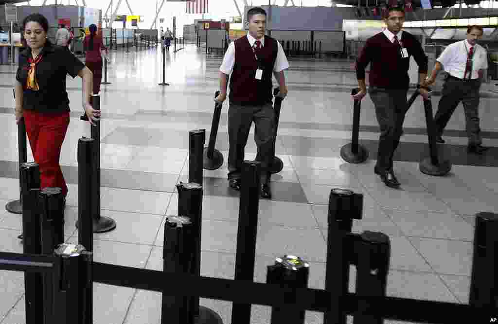Ticket agents remove the stanchions which form the ticketing lines at JFK International Airport as the city prepare for Hurricane Irene to hit in New York, New York. (Reuters Image)