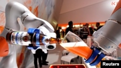 已被中國收購的德國機器人巨頭“庫卡”公司在漢諾威舉行的工業展銷會上展示機器人手臂倒一杯德國啤酒。 （2017年4月24日）