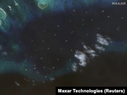 Maxar Technologies2024年11月25日拍摄的卫星图像显示，在南中国海斯普拉特利群岛(Spratly Islands,中国称南沙群岛)的铁峙岛(Thitu Island,中国称中业岛) 附近有一支据信来自中国的海上民兵渔船船队。
