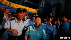2014年10月8日，香港警察护送一名反对占中者离开民主示威区域，以免发生对抗。