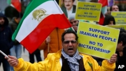 一名抗议者在比利时布鲁塞尔的欧盟委员会外面呼喊反对伊朗总统鲁哈尼的口号。（2018年1月3日）