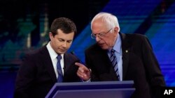 Democratic presidential candidates South Bend Mayor Pete Buttigieg, left, and Sen. Bernie Sanders talk during a break, Sept. 12, 2019, during a Democratic presidential primary debate in Houston.