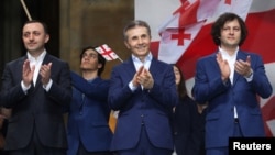 在格鲁吉亚首都第比利斯，格鲁吉亚总理伊拉克利·科巴希泽（右）、前总理兼格鲁吉亚梦想党主席伊拉克利·加里巴什维利（左）和前总理兼格鲁吉亚梦想党创始人比季娜·伊万尼什维利参加支持“外国代理人”法案的亲政府集会。（2024年4月29日）