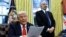 U.S. President Donald Trump reads about tariffs on steel and aluminum, as Howard Lutnick stands in the background, in the Oval Office of the White House in Washington, Feb. 10, 2025. 