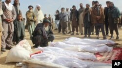 阿富汗平民聚集在冲突中死亡者周围。