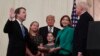 President Donald Trump, center, listens as retired Supreme Court Justice Anthony Kennedy, right, ceremonially swears-in Supreme Court Justice Brett Kavanaugh, left, in the East Room of the White House in Washington, Oct. 8, 2018. 