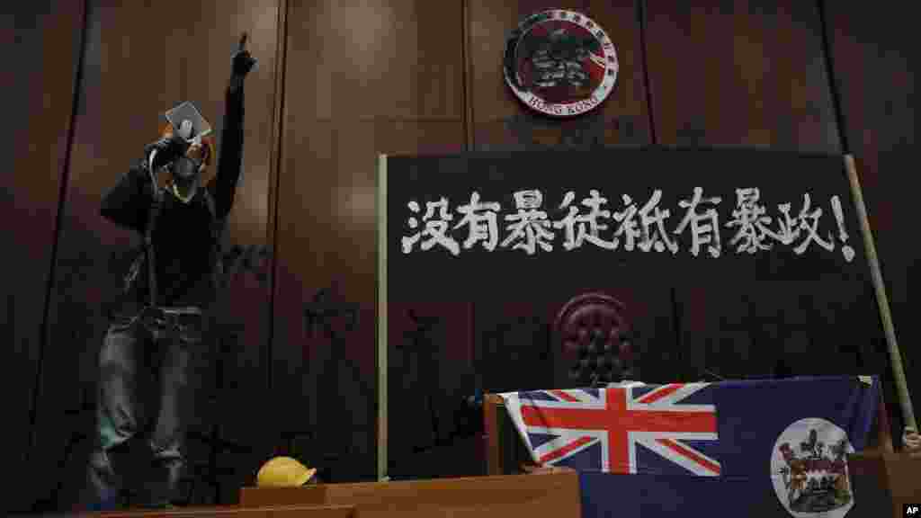 闖入立法會的示威者用噴漆塗黑主席台後的香港特區區徽，放置1997年前的香港殖民地旗，及插上&ldquo;沒有暴徒只有暴政&rdquo;的橫額。