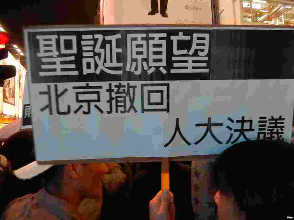 有「購物團」人士高舉聖誕願望標語，要求中國全國人大常委會撤回8-31落閘決定