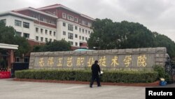 ຜູ້​ຊາຍ​ຄົນ​ນຶ່ງວາງ​ຊໍ່​ດອກ​ໄມ້​ຢູ່​ໜ້າ​ທາງ​ເຂົ້າ​ວິ​ທະ​ຍາ​ໄລ​ວິ​ຊາ​ຊີບ ວູ​ສີ, ລຸນຫຼັງ​ການ​ໂຈມ​ຕີ​ດ້ວຍ​ມີດ, ເມືອງ ວູ​ສີ, ແຂວງ ຈຽງ​ຊູ, ຈີນ, 17 ພະ​ຈິກ 2024.