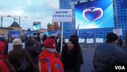 3月18日莫斯科紅場慶祝俄羅斯吞併克里米亞的一個集會上。普京的支持者手舉寫上：我們信任普京的標語牌。 (美國之音白樺)