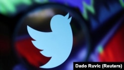 资料照 - 推特商标，背景是放大了的股市走势屏幕。