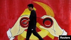 一名男子从上海街头中共党徽前走过。（2019年9月25日）