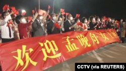 在廣東深圳寶安國際機場打著橫幅歡迎孟晚舟回國的人群。 （2021年9月25日）