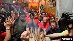 ​ປະ​ຊາ​ຊົນ​ຜູ້​ມີ​ຄວາ​ສັດ​ທາ​ຍາດ​ກັນ​ປັກ​ທູບ​ໃສ່​ໄຫ​ຄຳ​ຕອນ​ທ່ຽງ​ຄືນ​ຂອງ​ກຸດ​ຈີນດ ເຊິ່ງ​ແມ່ນ​ປີ​ງູ, ຢູ່​ວັດ ລຽງ ນຳ, ປະ​ເທດ ສິງ​ກະ​ໂປ, 28 ມັງ​ກອນ 2025.