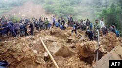 救援人員星期四在發生山體滑坡彝良縣學校現場進行搶救工作