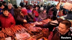 置办年货的北京市民在超市的腊肉腊肠摊位前选购。（2020年1月16日）