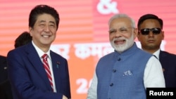 日本首相安倍晉三與印度總理莫迪在艾哈邁德巴德的高鐵動工儀式上握手。