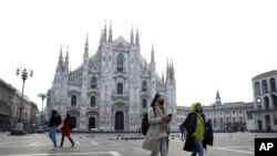 一名戴口罩的婦女走過米蘭的大教堂廣場