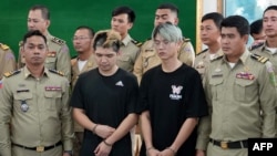 這張由西哈努克省行政當局於2024年2月15日拍攝並發布的傳單照片顯示，台灣男子陳能釧(中左)和魯祖顯(中右)在西哈努科省的一場新聞記者會上與警方站在一起，他們因播放假綁架影片而被捕。（法新社）