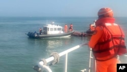 台湾海巡署公布照片显示2024年2月14日海巡人员在金门海域调查一艘中国籍快艇越界进入禁区水域。