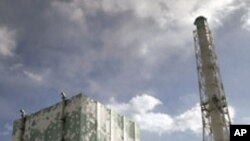 Tokyo Electric Power Co. (TEPCO)'s tsunami-crippled Fukushima Daiichi nuclear power plant No.6 (L) and No.5 reactor buildings are seen from a bus window in Fukushima prefecture, February 20, 2012