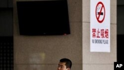 一名煙民站在禁煙告示下吸煙