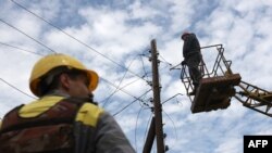 Электрики восстанавливают электросеть, поврежденную российскими авиаударами. Донецкая область. Июль 2024 г. (архивное фото) 