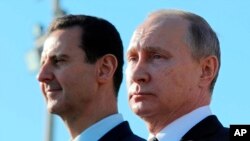 俄罗斯总统普京在叙利亚总统阿萨德陪同下在叙利亚哈迈尼姆航空基地检阅部队。（2017年12月11日）