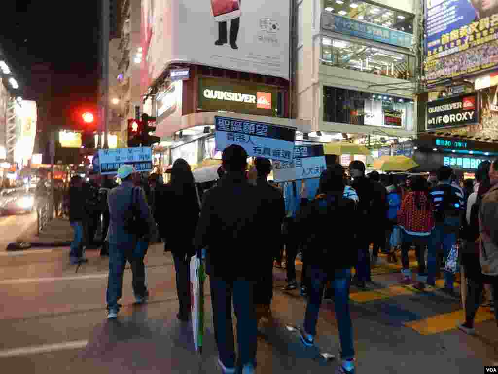 警方向旺角「購物團」人士高舉警告標語，將部份人封鎖在一條馬路上