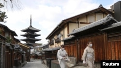 日本京都兩名戴著口罩的婦女走過空蕩蕩的街頭。 （路透社2021年1月13日）