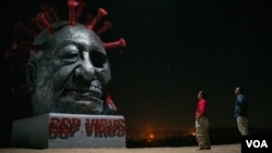 雕塑家陳維明和蘇立德站在他們的作品“中共病毒”前（美國之音記者文灝拍攝）