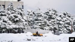 ພະນັກງານ ກໍາລັງໃຊ້ລົດດຸດກວດຫິມະ ຢູ່ທີ່ລັດຖະສະພາໃນນູຄອນຫຼວງໂຊລ, ເກົາຫຼີໃຕ້, ວັນພຸດ, ທີ່ 27 ພະຈິກ 2024. (AP Photo/Lee Jin-man)