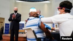 美国总统拜登在弗吉尼亚神学院设立的新冠疫苗接种站为接种疫苗的民众鼓掌。(2021年4月6日)