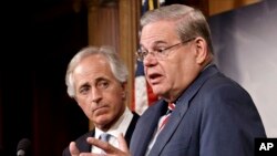 美国参议院外交委员会主席梅嫩德斯与（右）3月27日在国会山举行的记者会上