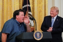 U.S. President Donald Trump applauds Bruce Hrobak, owner of Billy Bones Bait &amp; Tackle, as he expresses his support for the president during an event in the East Room of the White House, July 8, 2019.